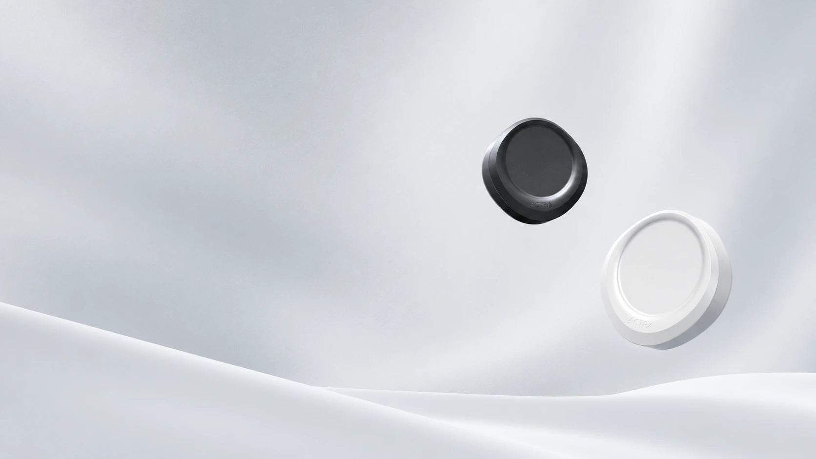 Black and pearl white ACTRA devices above a softly sculpted silver surface