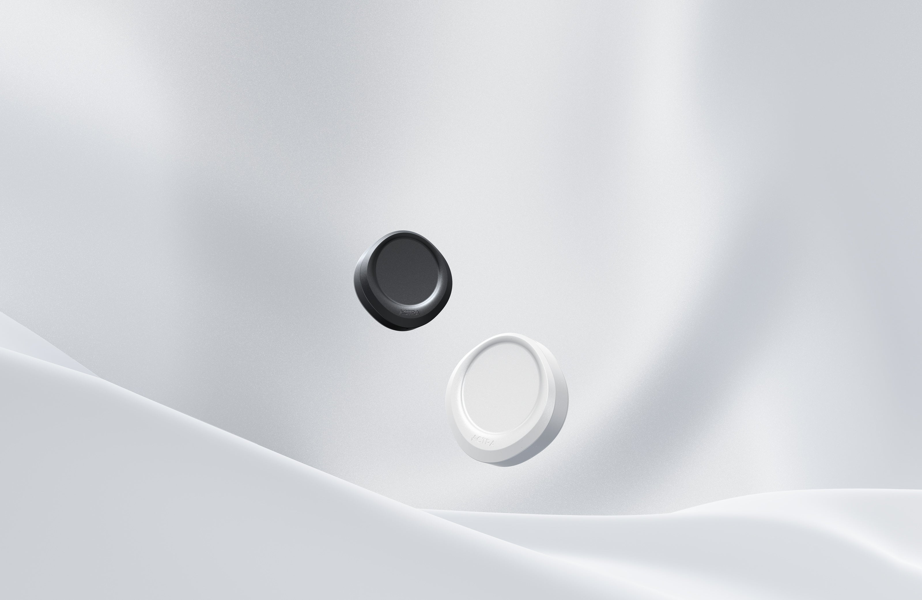 Black and pearl white ACTRA devices above a softly sculpted silver surface